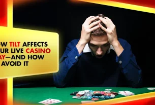 man holding his head on a live casino table with poker chips and playing cards